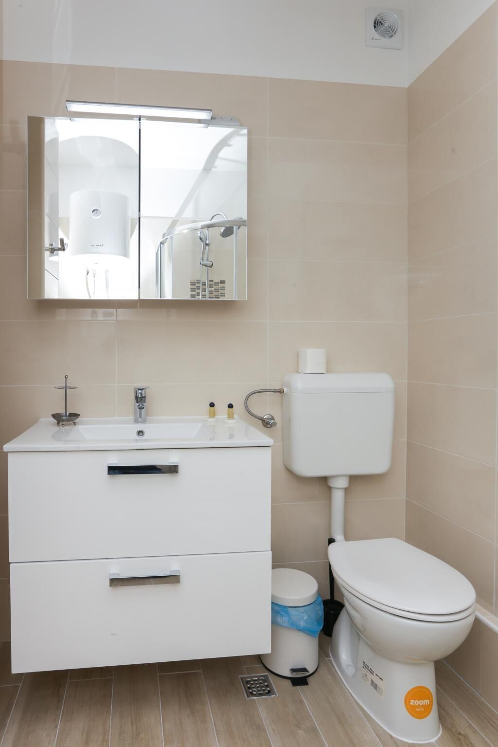 Une salle de bain moderne avec un lavabo blanc, un miroir et des toilettes.