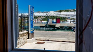A marina with boats, a covered walkway, and a sign indicating free parking. - Orka Apartments - Studio (2 Adults) (Dubrovnik)