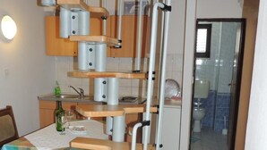 A kitchen with a wooden staircase and a dining area.