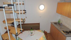 A compact kitchen with a dining table, chairs, a bench, and a built-in stove.