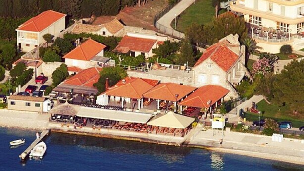 An aerial view of a coastal town with buildings, a dock, and boats.
