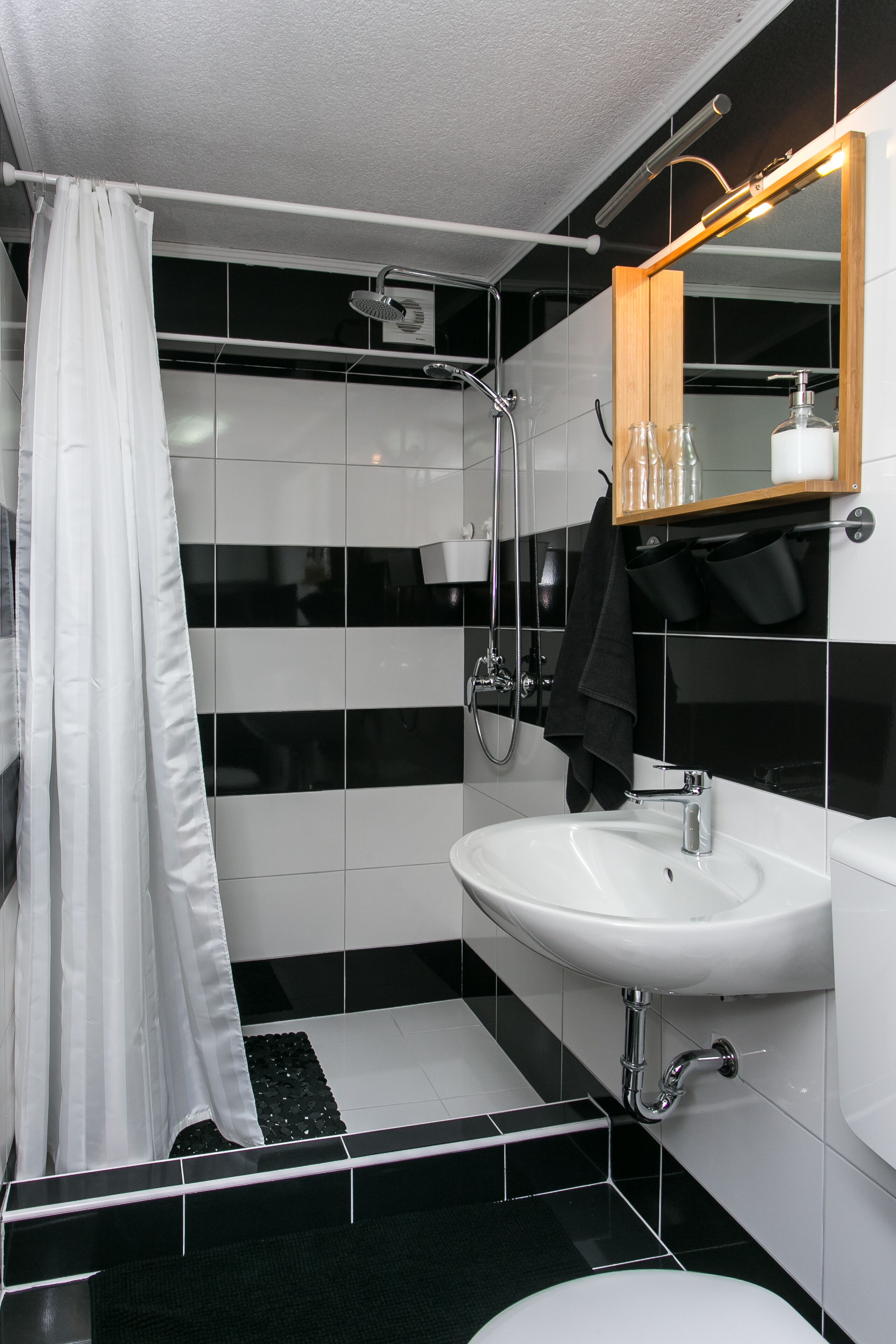 A modern bathroom with a shower, sink, and toilet.