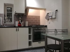 Enjoy cooking in this well-equipped kitchen with a gas stove, oven, and ample counter space.
