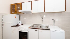 A compact kitchen with a refrigerator, stove, oven, sink, and a microwave. - Apartment Berk - One-Bedroom Apartment with Terrace (Dubrovnik)