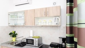 A modern kitchen with a microwave, toaster, and coffee maker on the counter. - Apartments Kapelica - Studio apartment (Dubrovnik)