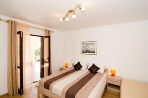 A bedroom with a bed, two bedside tables, a nightstand, a window with curtains, a ceiling light fixture, and a framed picture on the wall. - Villa Barbara - Comfort Studio with Terrace and Sea View (br. 1) (Mlini)