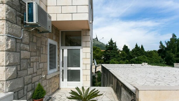 Un bâtiment en pierre doté d’un balcon, d’une porte et d’une fenêtre.