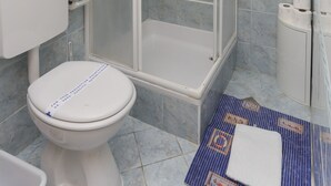 A bathroom with a toilet, a shower enclosure, and a sink. - K-Apartments - Double or Twin Room with Garden View - A3 (Dubrovnik)