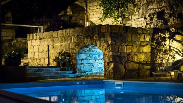 Una piscina con muros y arco de piedra.