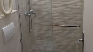 A shower with a textured wall, a hand dryer, and a towel rack. - Apartments Magda- Standard Backside Studio Apartment (Cavtat)
