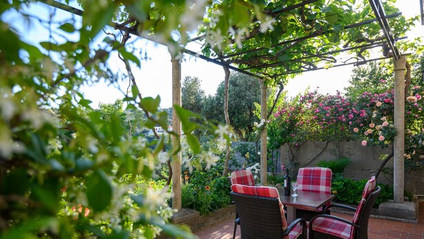Eine Außenpatio mit Korbmöbeln und einer Pergola.