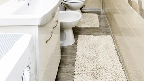 Ein modernes Badezimmer mit einer Duschkabine aus Glas, einem Waschbecken und einer Toilette.