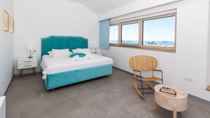 Une chambre moderne avec un lit, une chaise, une petite table et une fenêtre donnant sur un beau paysage.