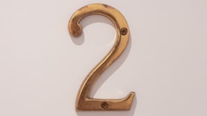Una placa de latón con el número 2 en una puerta blanca.