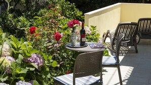 An outdoor patio with a table set for two, featuring a bottle of wine, a glass, and a menu. - Guest House Rooms Rose - Romantic Double Room with Balcony and Sea View (No.2) (Molunat)