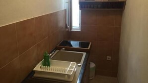 Une petite cuisine avec une fenêtre, un évier et un plan de travail.
