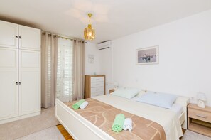 Relax in this inviting room featuring a large bed, nightstand, dresser, and framed artwork.
