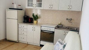 Cozinha compacta com geladeira, fogão e armários.