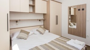 Une chambre à coucher avec un lit, des tables de chevet, une armoire et un miroir.