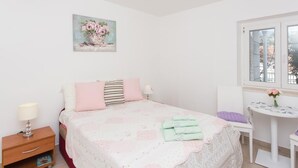 Une chambre à coucher avec un lit, une table de chevet, une lampe et une fenêtre donnant sur un beau paysage.