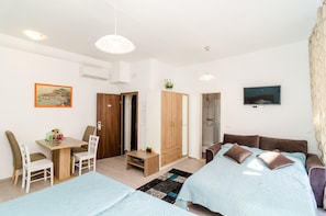 Une chambre à coucher moderne avec un lit, un bureau et un téléviseur.
