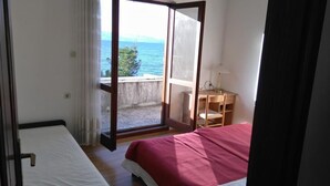 Une chambre avec un lit, un bureau et une vue sur la mer.