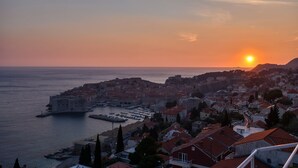 A coastal cityscape with a prominent historic building by the sea, a marina, and residential areas. - Rooms Raic - Studio Apartment (Olive) (Dubrovnik)