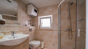 A bathroom with a sink, toilet, and glass-enclosed shower. - Rooms Raic - Studio Apartment (Olive) (Dubrovnik)
