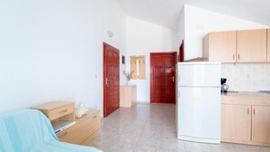 A compact kitchen with wooden cabinets, a white refrigerator, and a small countertop. - Apartments Ana & Bogdan - One Bedroom Apartment with Balcony and Sea View (A2) (ST) (Postira)