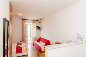 Quarto de hotel com duas camas, televisão, máquina de café e janela com cortinas.