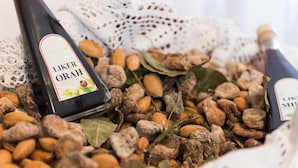 Dos botellas de vino Liker Orah rodeadas de almendras y hojas de laurel.