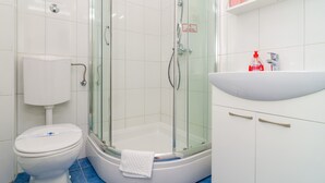 Ein Badezimmer mit Toilette, einer Duschkabine, einer Badewanne und einem Waschbecken.