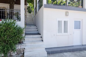 Un edificio blanco con una escalera que lleva a un balcón.
