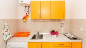 A kitchen with a washing machine, a sink, and a dish rack. - Apartments Elelu-Two-Bedroom Apartment with Terrace (Dubrovnik)