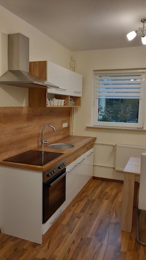 Kitchen features an oven, stainless steel sink, and white cabinetry.
