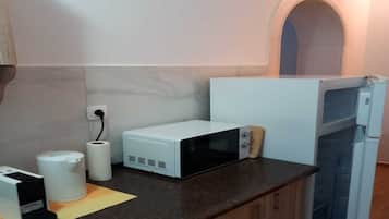 A kitchen with a microwave, a toaster, and a refrigerator.