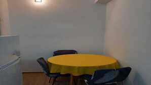 A small dining area with a yellow table and four chairs.
