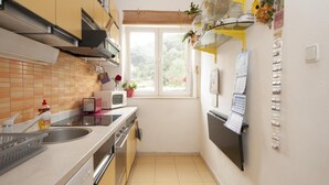 A compact kitchen with a window, a microwave, a toaster, and a sink. - Apartments Kalajzic- One-Bedroom Apartment with Terrace (Pucisca)