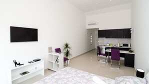 A modern apartment with a living area, a kitchen, and a dining space. - LUV Luxury Apartments - Studio Apartment with Balcony and Sea View (Dubrovnik)