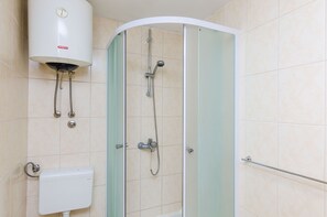 A shower with a glass door, a toilet, and a water heater. - Apartments Princ Hrvoje- Studio (Dubrovnik)