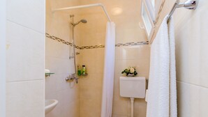 A small bathroom with a shower, toilet, and sink. - Rooms Batina- Standard Double Room (Dubrovnik)