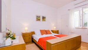 A bedroom with a bed, bedside tables, a desk, and a window. - Rooms Batina- Standard Double Room (Dubrovnik)