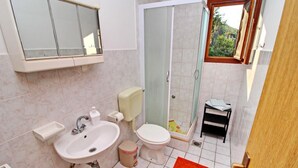 Een badkamer met een wastafel, toilet en douche.