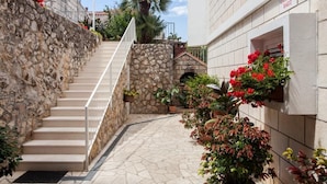 Una escalera de piedra que lleva a un edificio con un letrero que dice 'Guest House Raguz'.