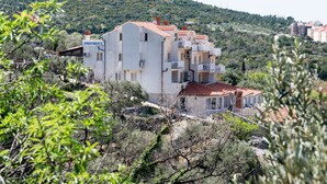 A multi-story building with balconies, surrounded by greenery and hills. - Villa Bell Memories- Two Bedroom Apartment with Shared Terrace and Sea View (Cavtat)