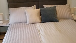 A bed with striped bedding, a headboard, and two bedside lamps. - Apartments Magda- Comfort Studio Apartment with Patio (Cavtat)