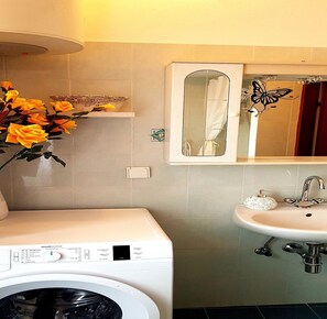 A bathroom with a washing machine, a sink, and a mirror. - Apartment Little Star - Two Bedroom Apartment with Terrace (Dubrovnik)