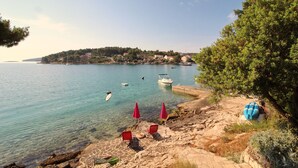 Une zone côtière caractérisée par des eaux limpides, un littoral rocheux et quelques bateaux.