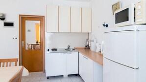 A compact kitchen with white cabinets, a microwave, a sink, and a coffee maker. - Apartments Veve - One Bedroom Apartment with Terrace Sea View (Postira)