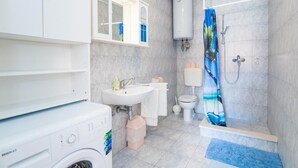 A bathroom with a washing machine, a sink, a toilet, and a shower. - Apartments Veve - One Bedroom Apartment with Terrace Sea View (Postira)
